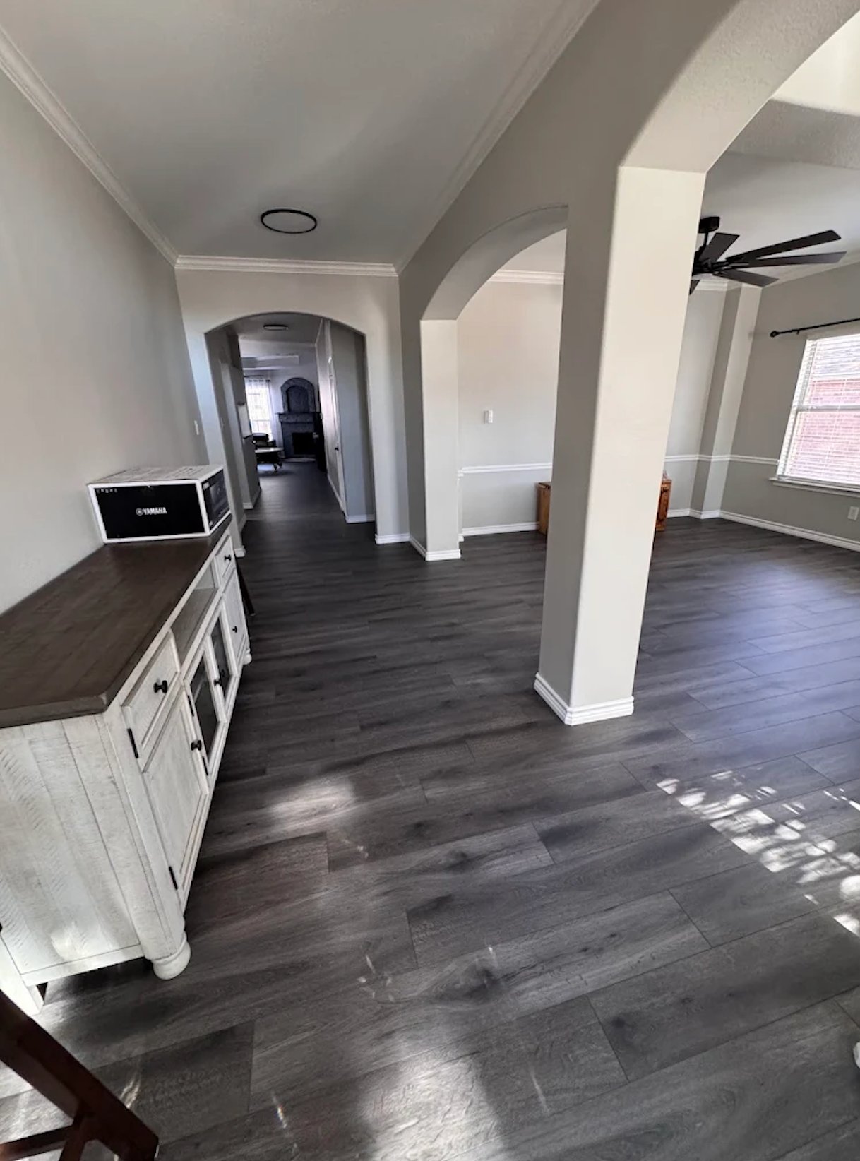 Open living area with new dark wood plank flooring and freshly painted gray walls by Alphex Painting and Remodeling